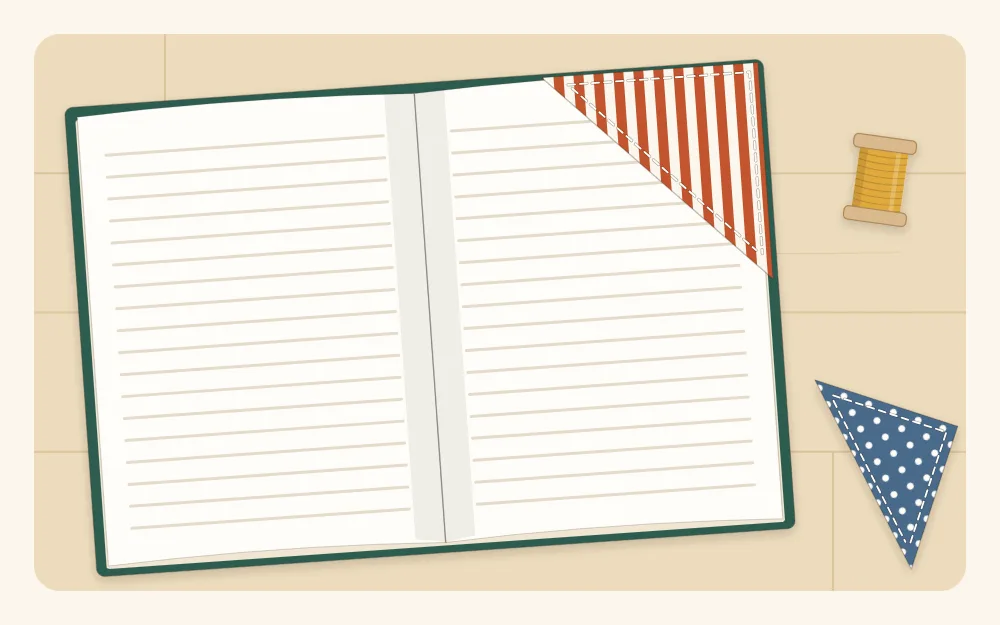 A triangular fabric corner bookmark slipped over the top corner of a book page