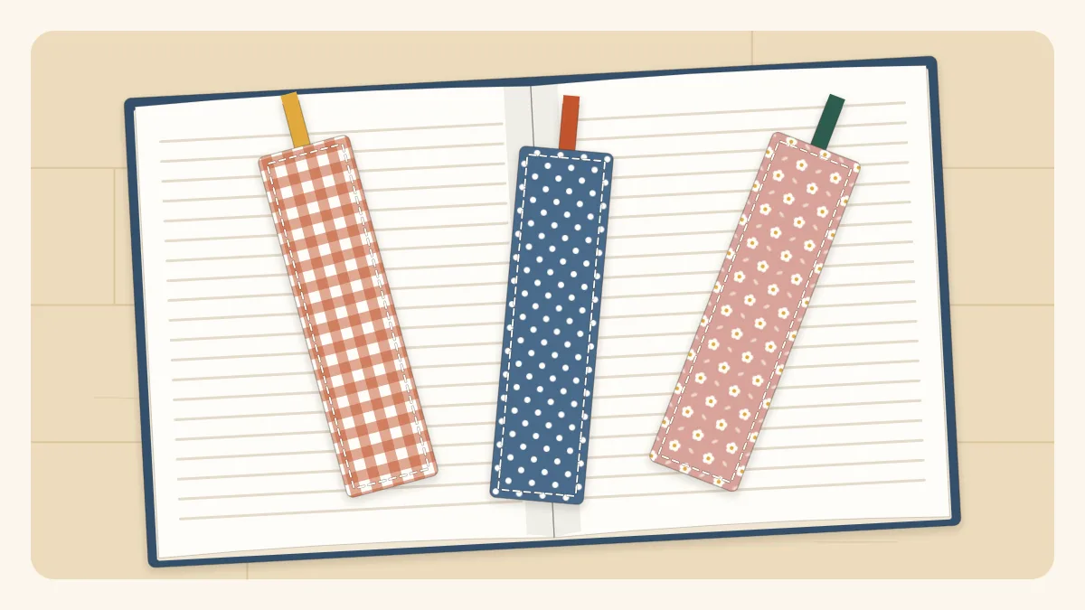 Three fabric bookmarks in different prints lying on an open book