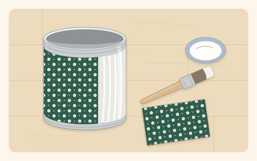 A tin partly wrapped in print fabric with a glue brush lying beside it