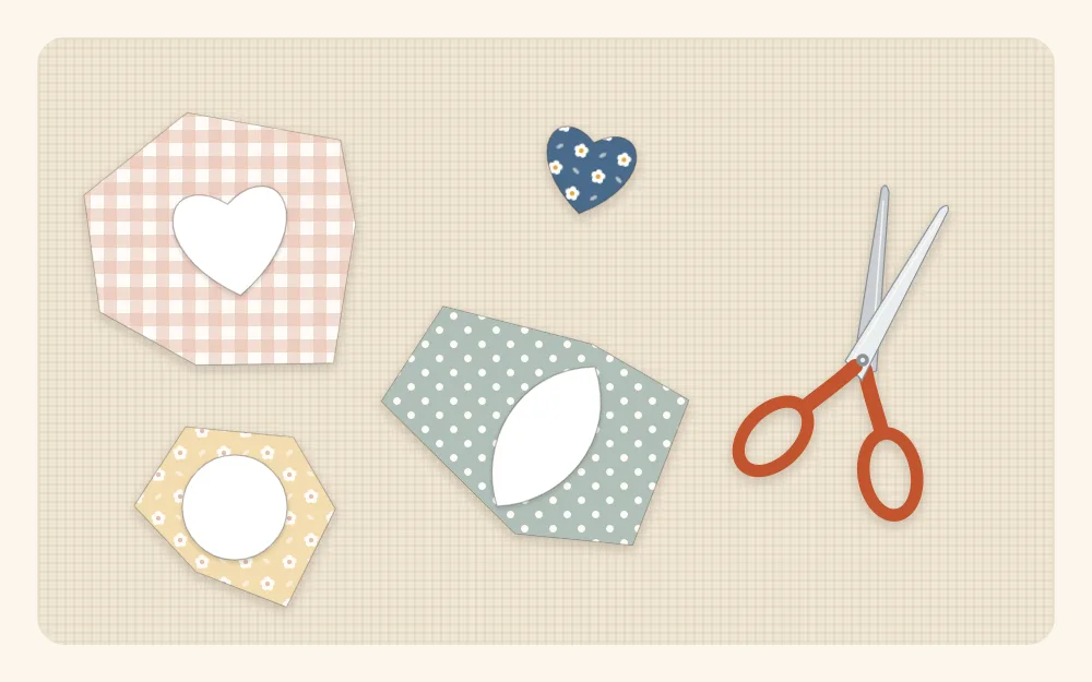Illustration of paper-backed heart and leaf shapes fused to the back of print fabric scraps, with small scissors beside them