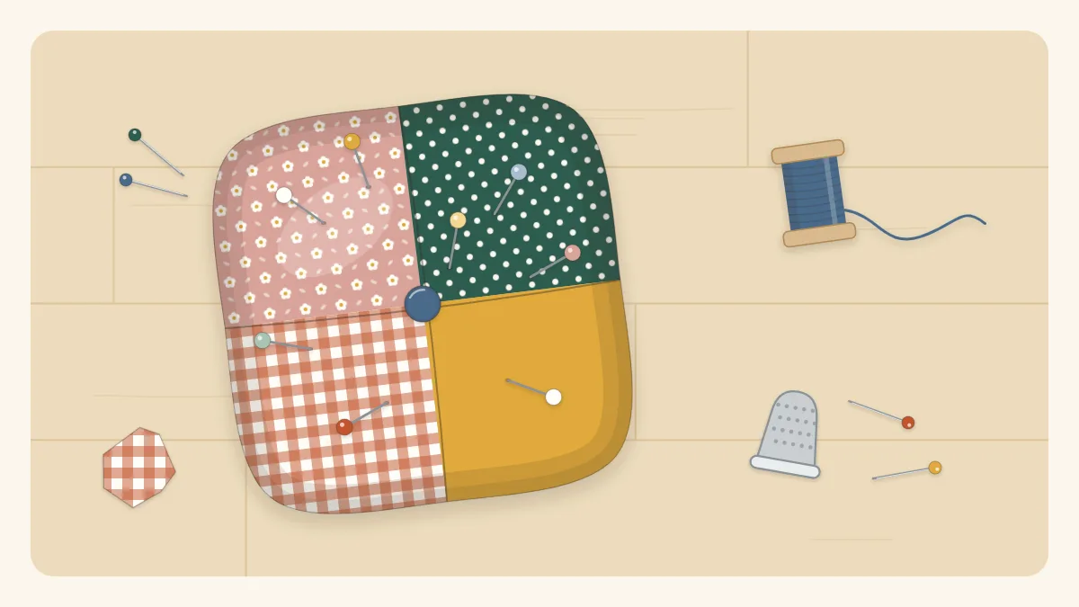 A plump square patchwork pincushion with pins in it